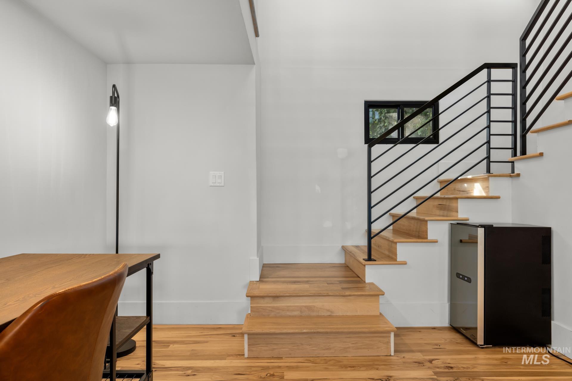 Stairway with wood finished floors and baseboards