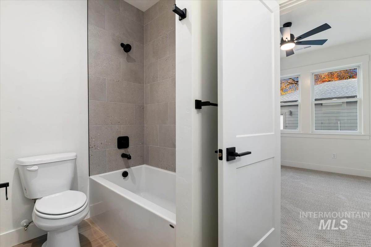 Full bath featuring shower / bathtub combination, carpet flooring, and a ceiling fan