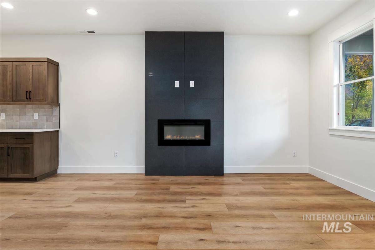 Unfurnished living room with recessed lighting, light wood-style floors, and a fireplace