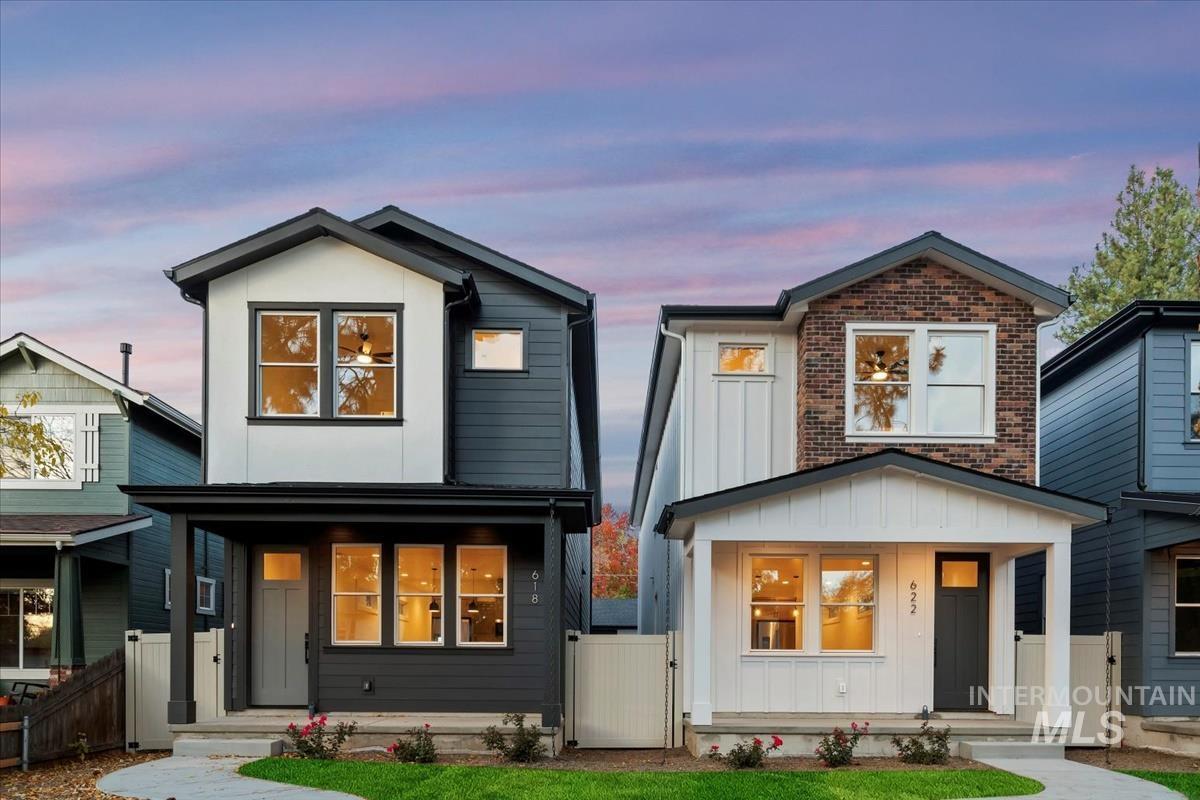 Contemporary house with board and batten siding, a porch, a gate, and brick siding