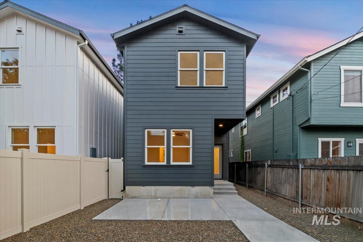 Back of property at dusk featuring a fenced backyard