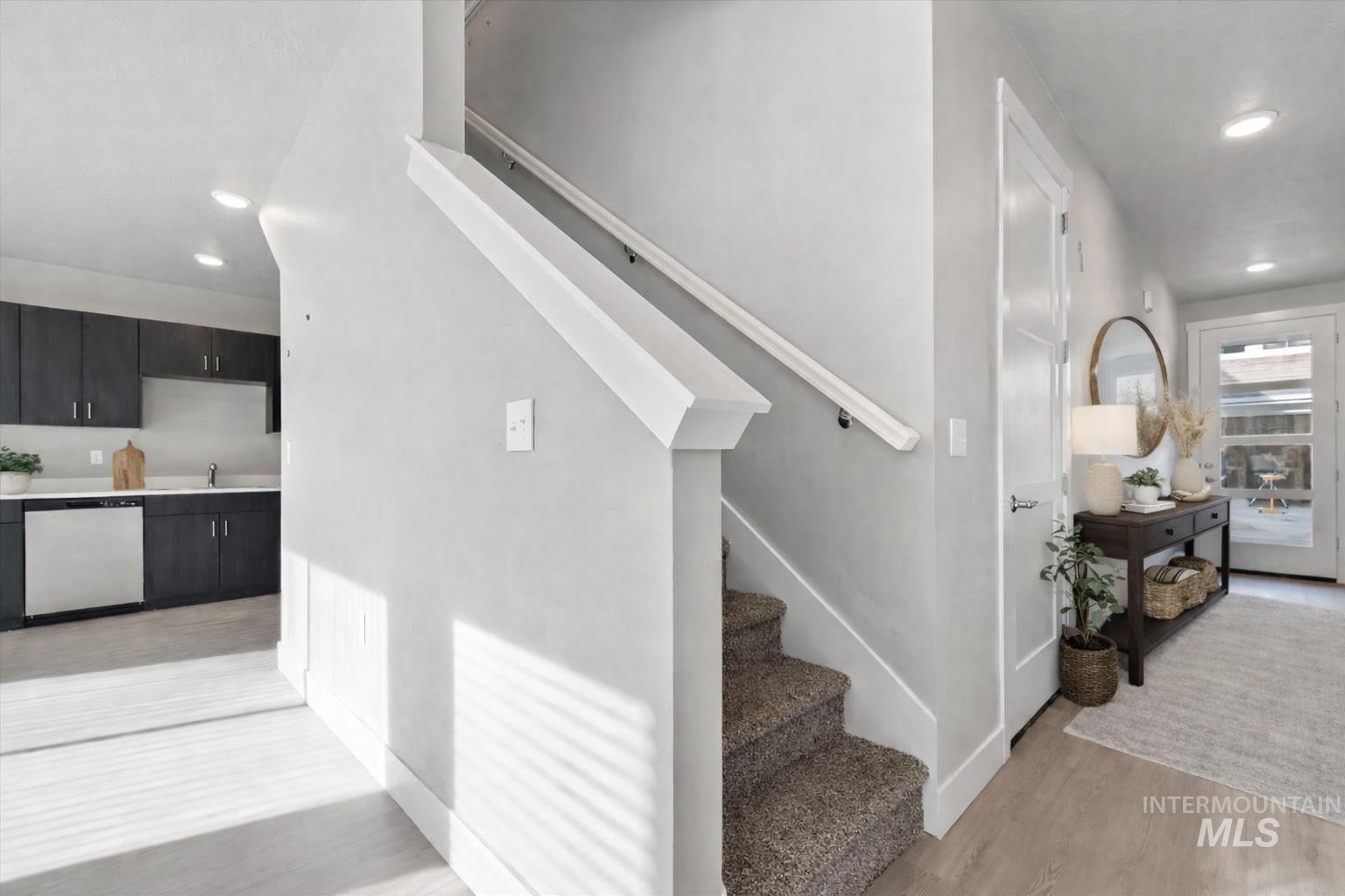Stairway with recessed lighting and wood finished floors