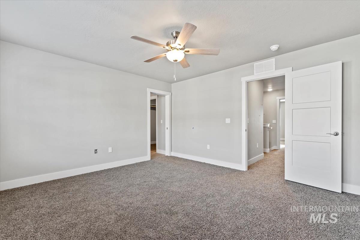 Unfurnished bedroom with light carpet and a ceiling fan