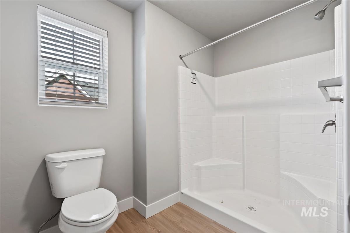 Full bathroom featuring a stall shower and light wood finished floors