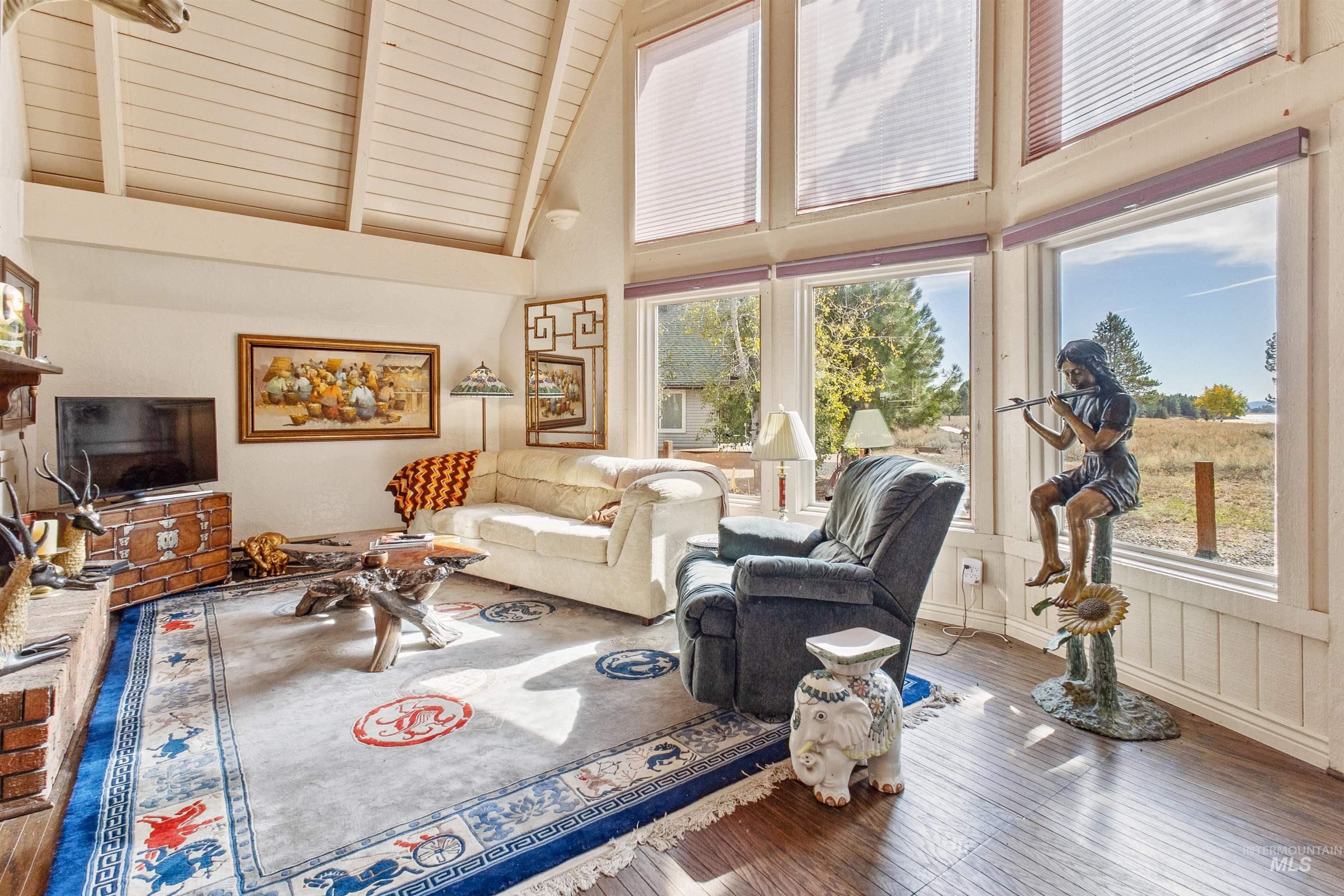 Living area with hardwood / wood-style flooring and high vaulted ceiling