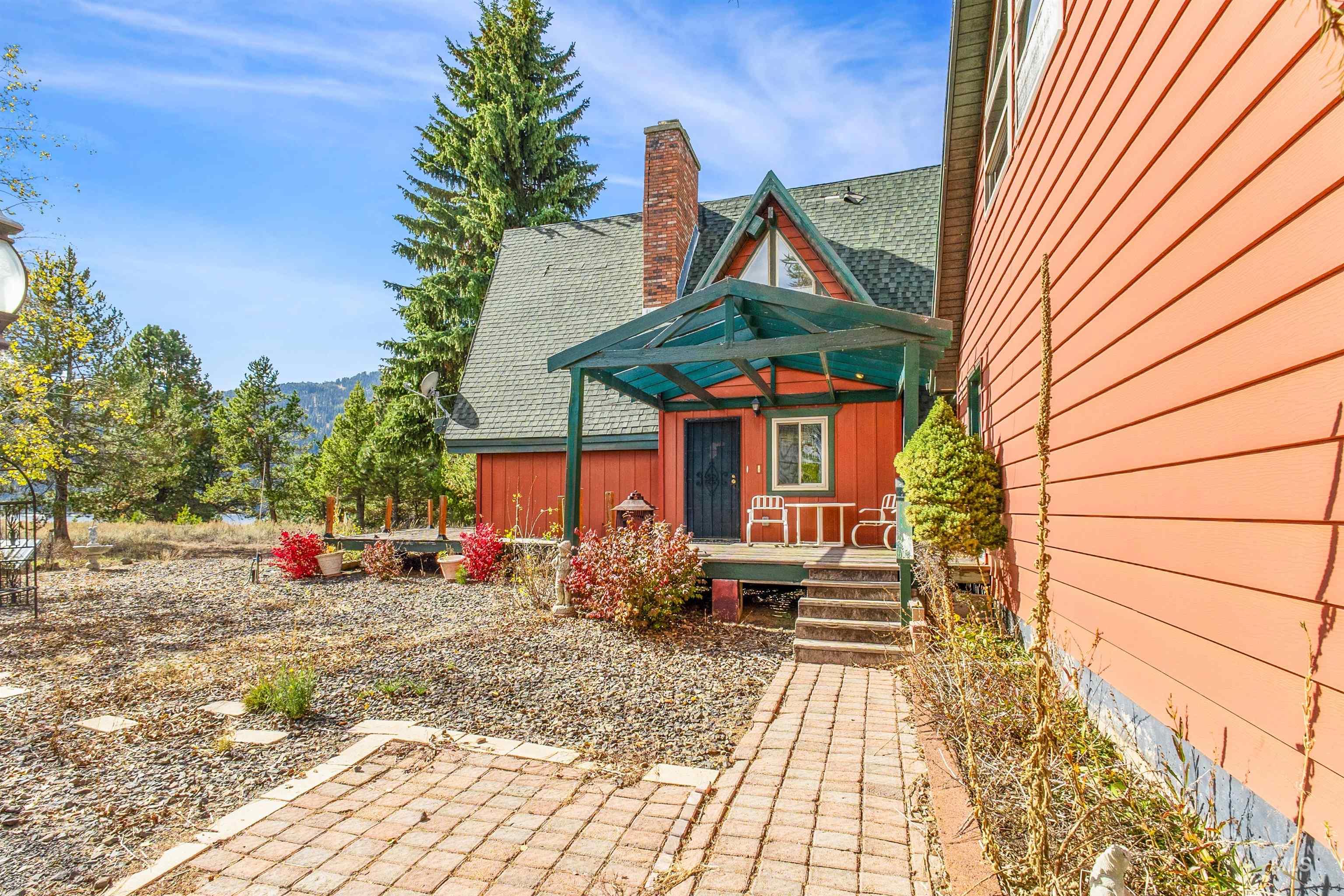 Entrance to property featuring a porch, a chimney, roof with shingles, and board and batten siding