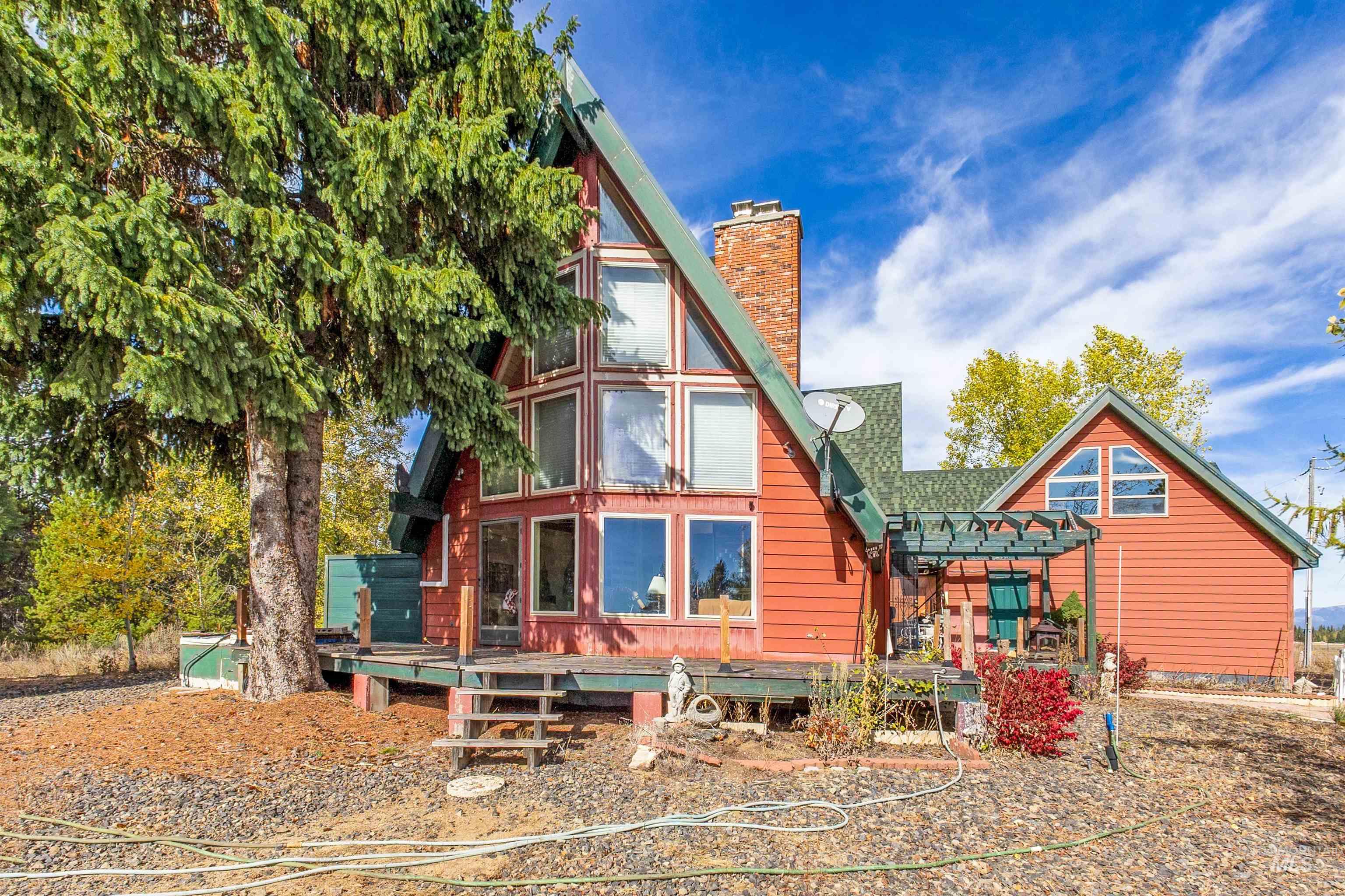 Rear view of property featuring a wooden deck and a chimney