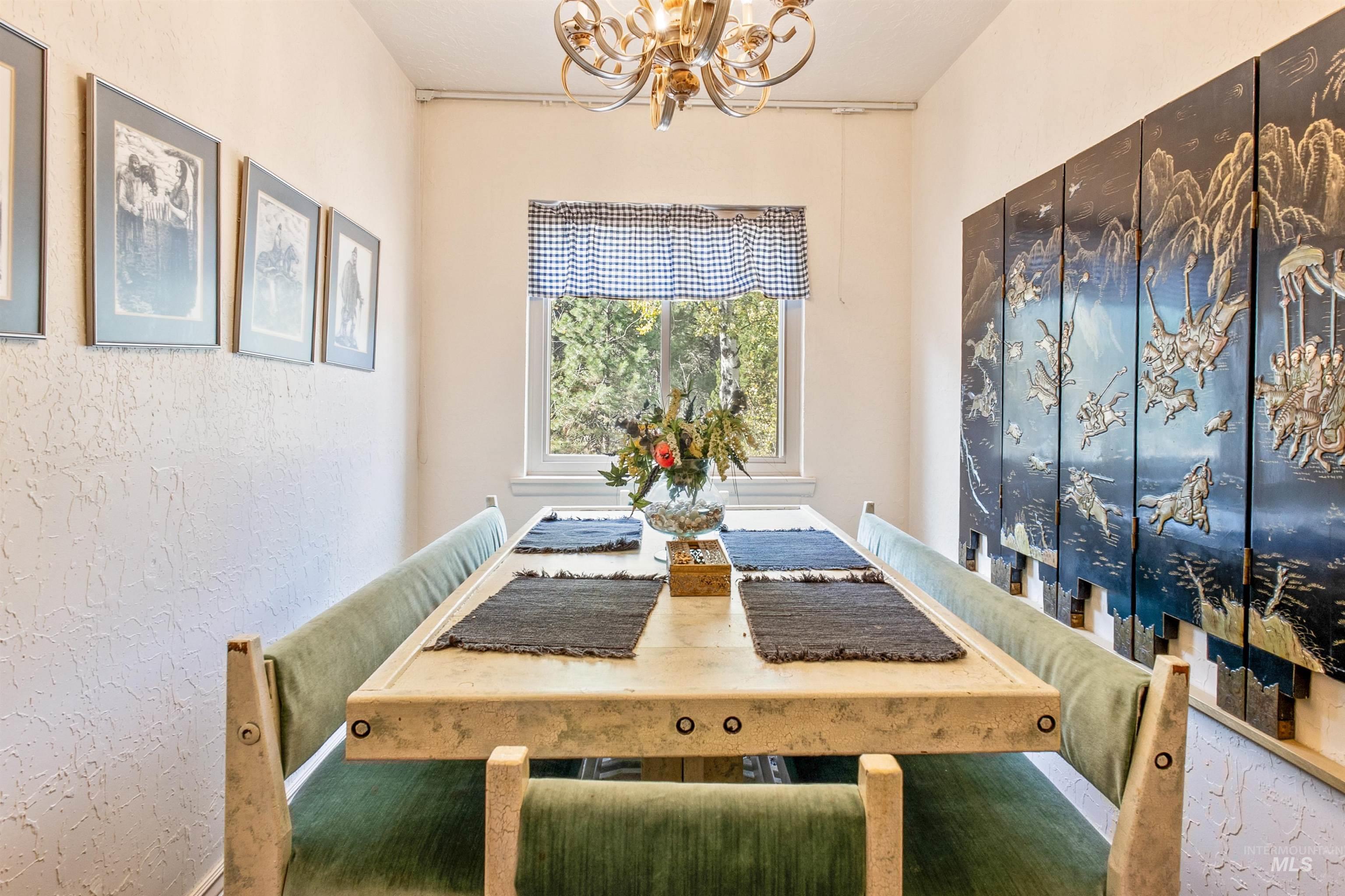 Dining area with a textured wall and a chandelier