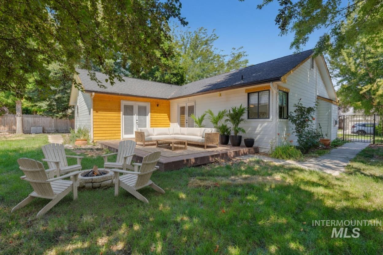 Expansive backyard featuring a raised wooden deck and mature shade trees. *Virtually Staged photo*