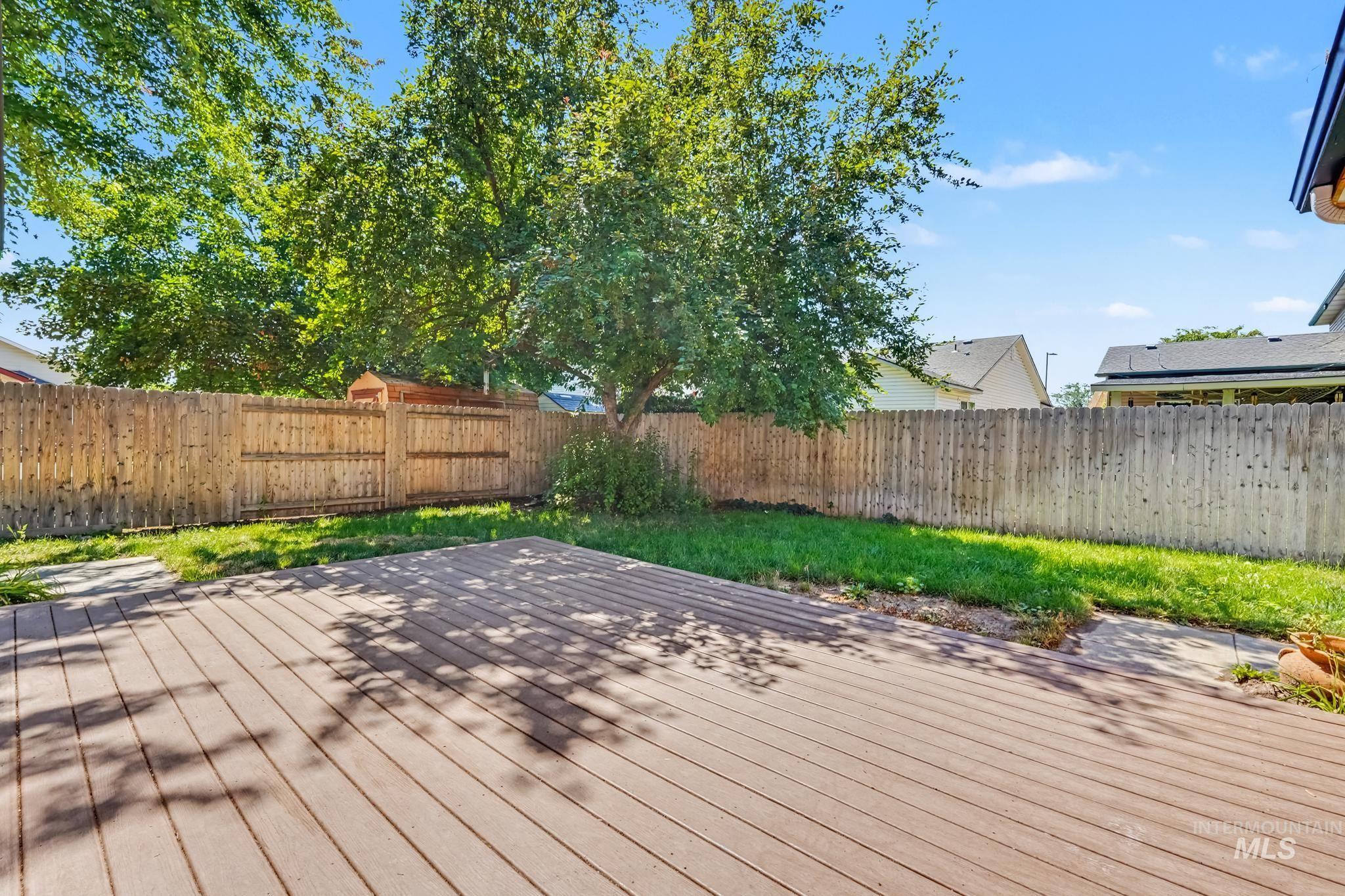 Outdoor decking with a privacy fence and established trees