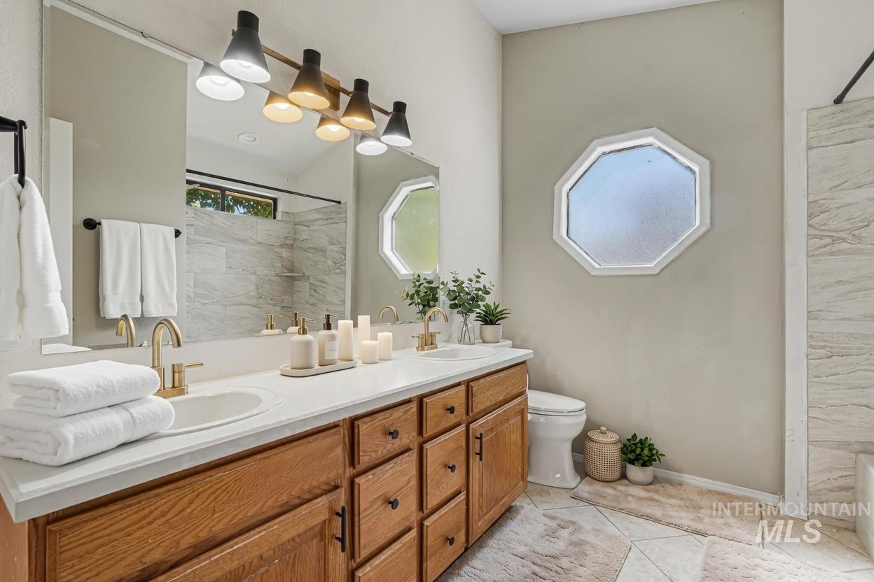 Dual vanity with a white countertop and wood cabinetry. *Virtually Staged photo*