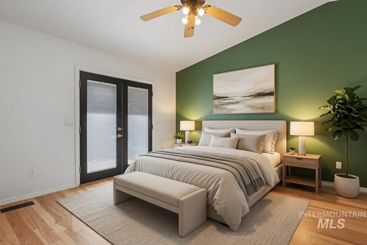 Spacious master room featuring light wood-finish flooring and a ceiling fan with integrated lighting. *Virtually Staged photo*