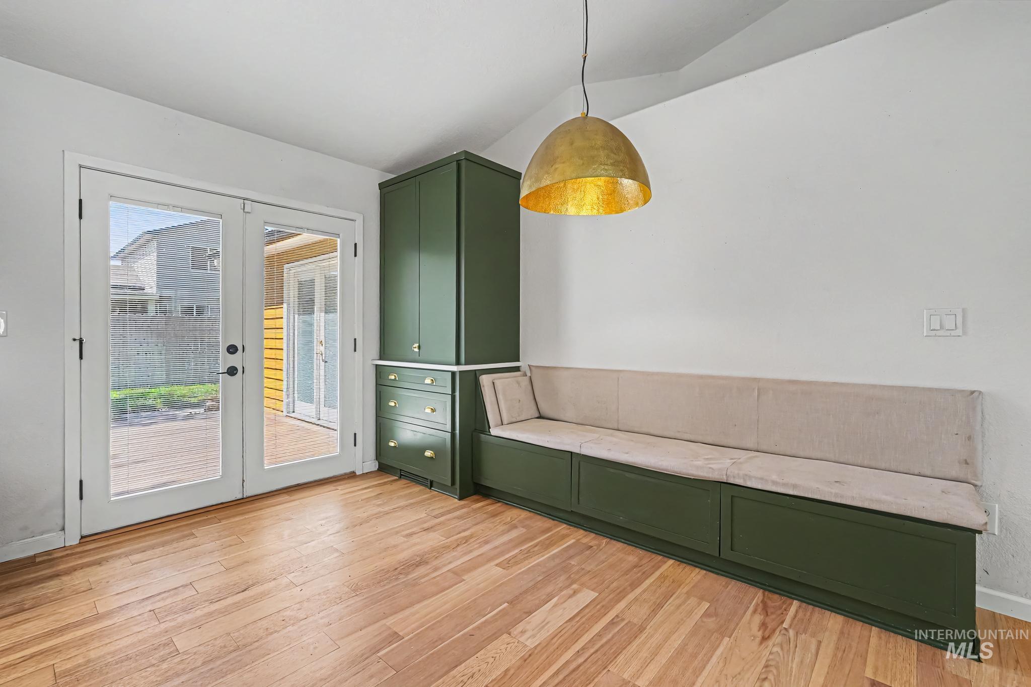 Built-in green cabinetry with gold hardware, integrated banquette seating, and wood-finish flooring