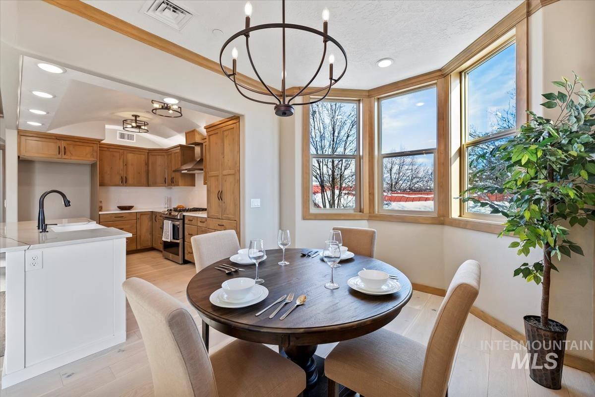 Dining space with a chandelier, light wood-type flooring, and recessed lighting