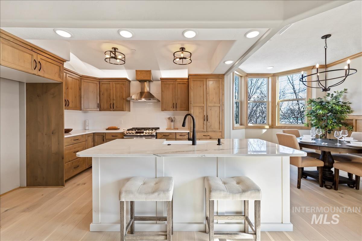 Kitchen featuring brown cabinetry, light countertops, light wood-style floors, and recessed lighting