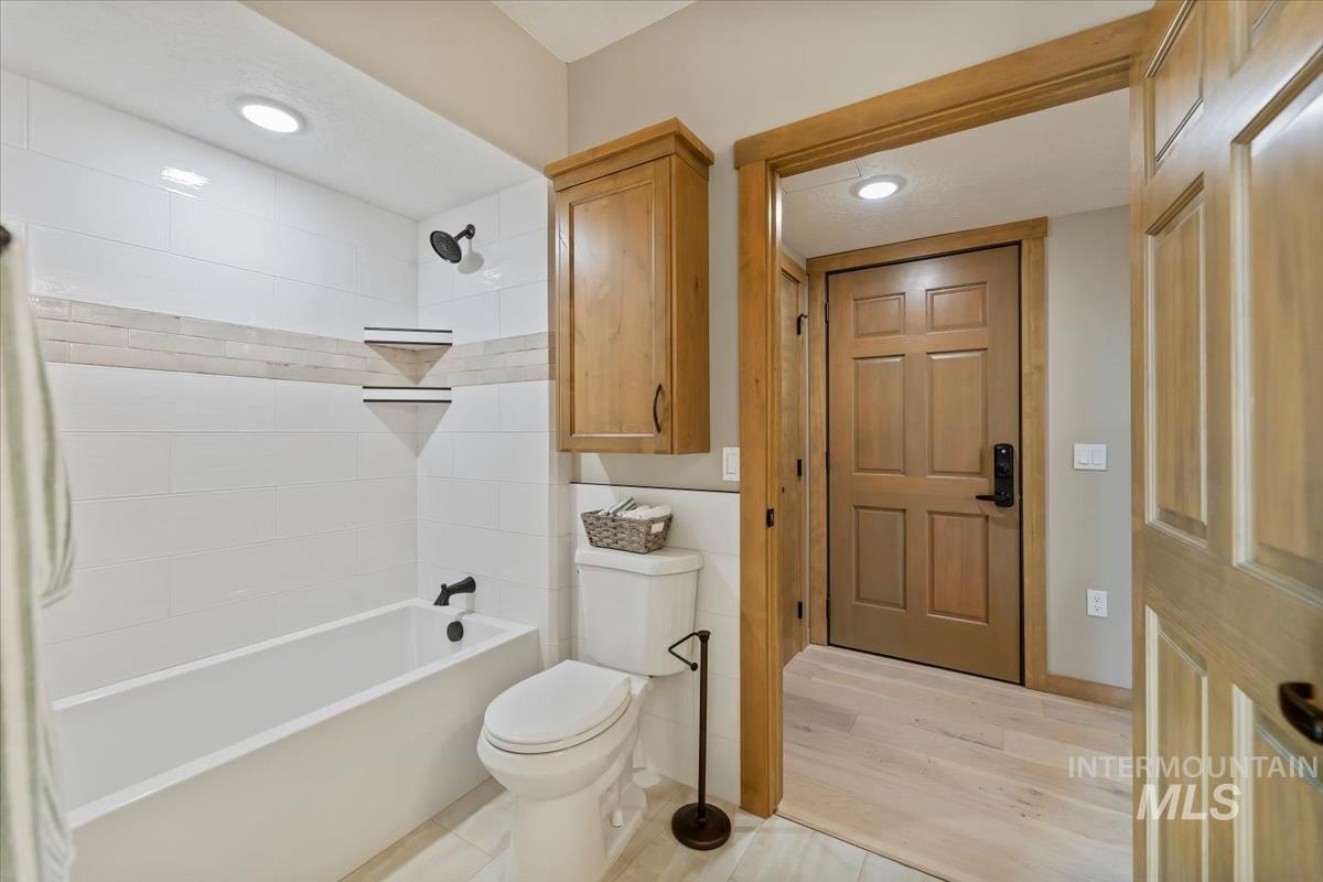 Bathroom with  shower combination, wood finished floors, and recessed lighting