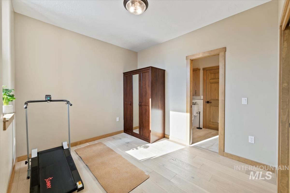 Workout area featuring light wood-type flooring and baseboards