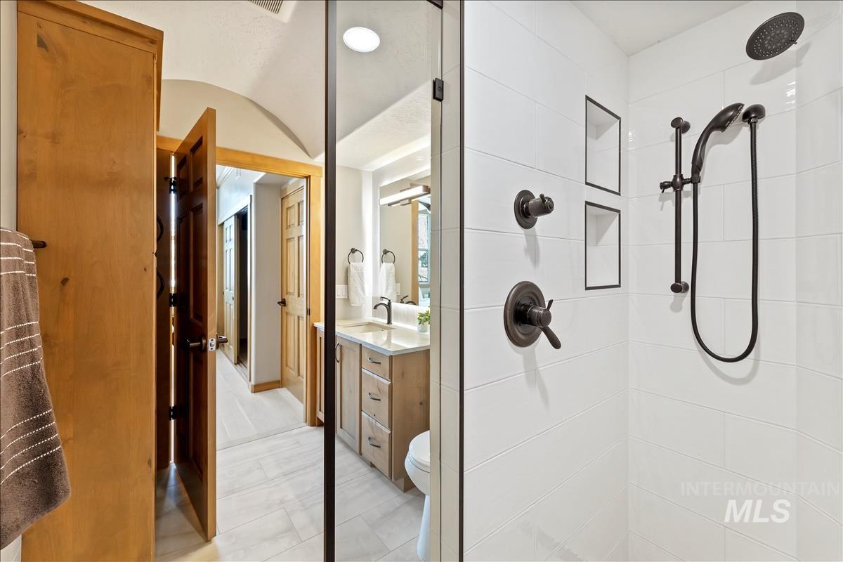 Bathroom featuring tiled shower and vanity