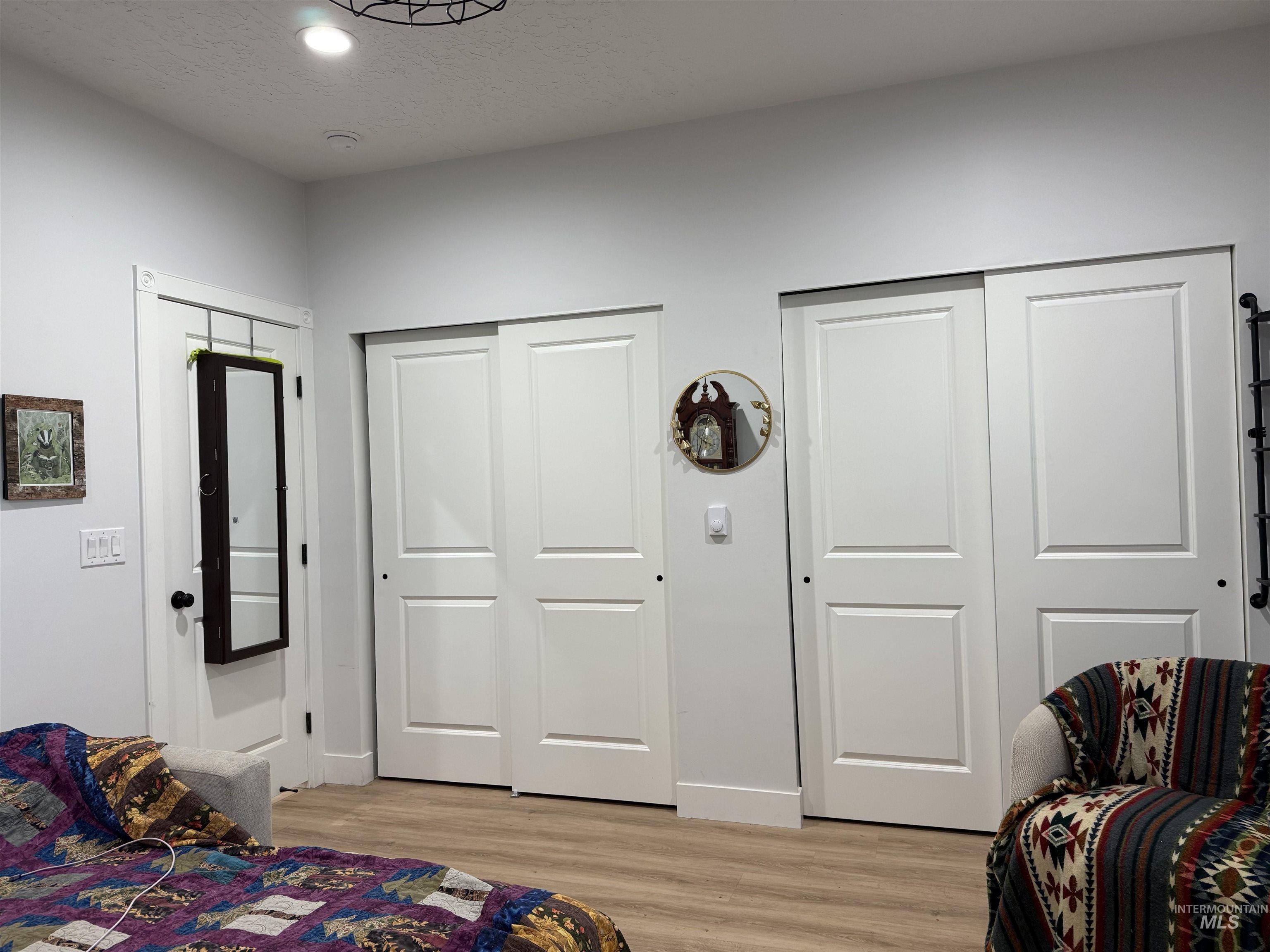Bedroom closets, LVP floors, recessed lighting, and a textured ceiling