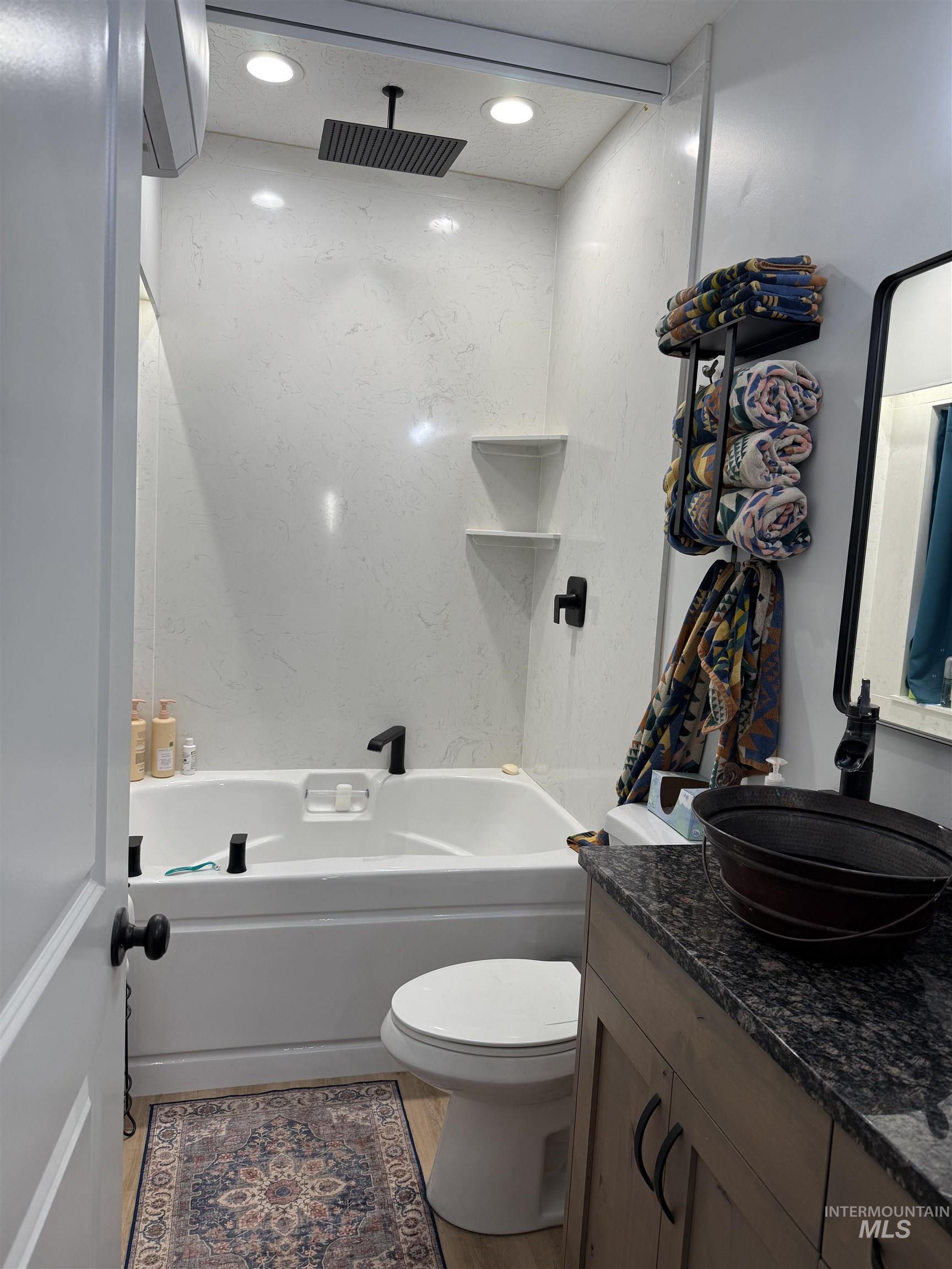 Full bath with vanity, soaking tub/shower combination, remote controled shower curtain, LVP flooring