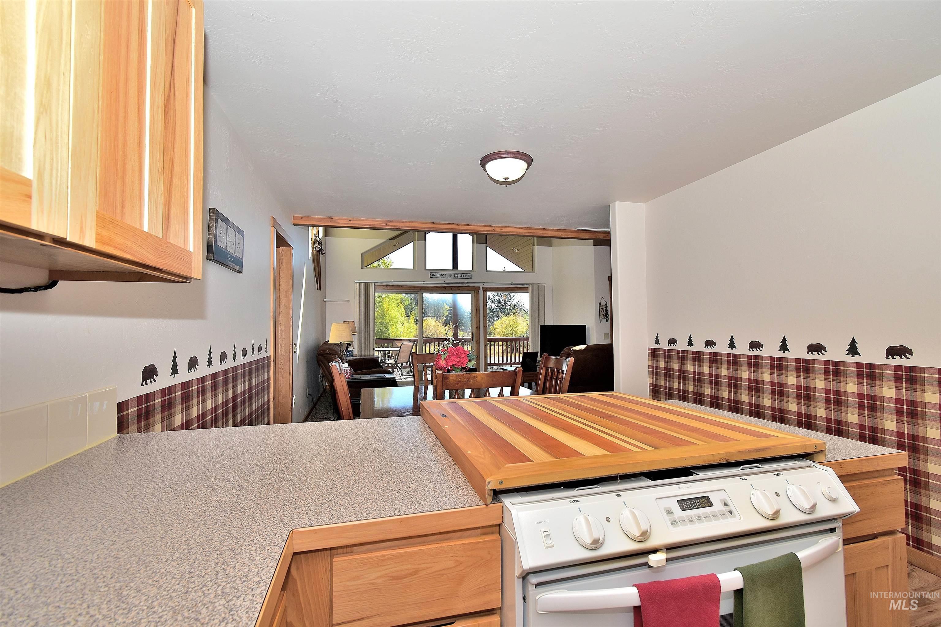 Kitchen with white range with electric cooktop and light brown cabinets