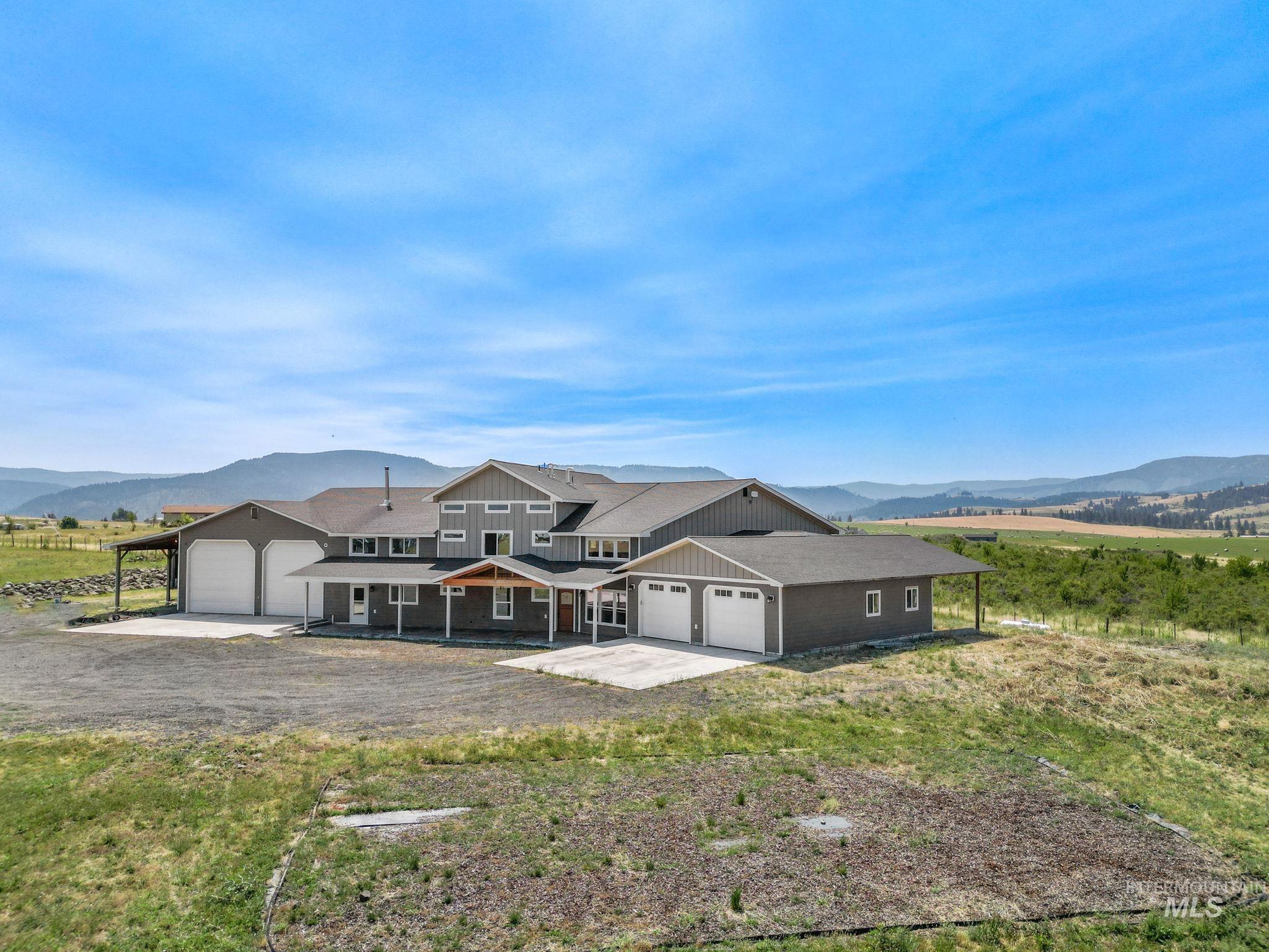 View of front facade featuring a mountain view, driveway, a view of rural / pastoral area, and a patio area