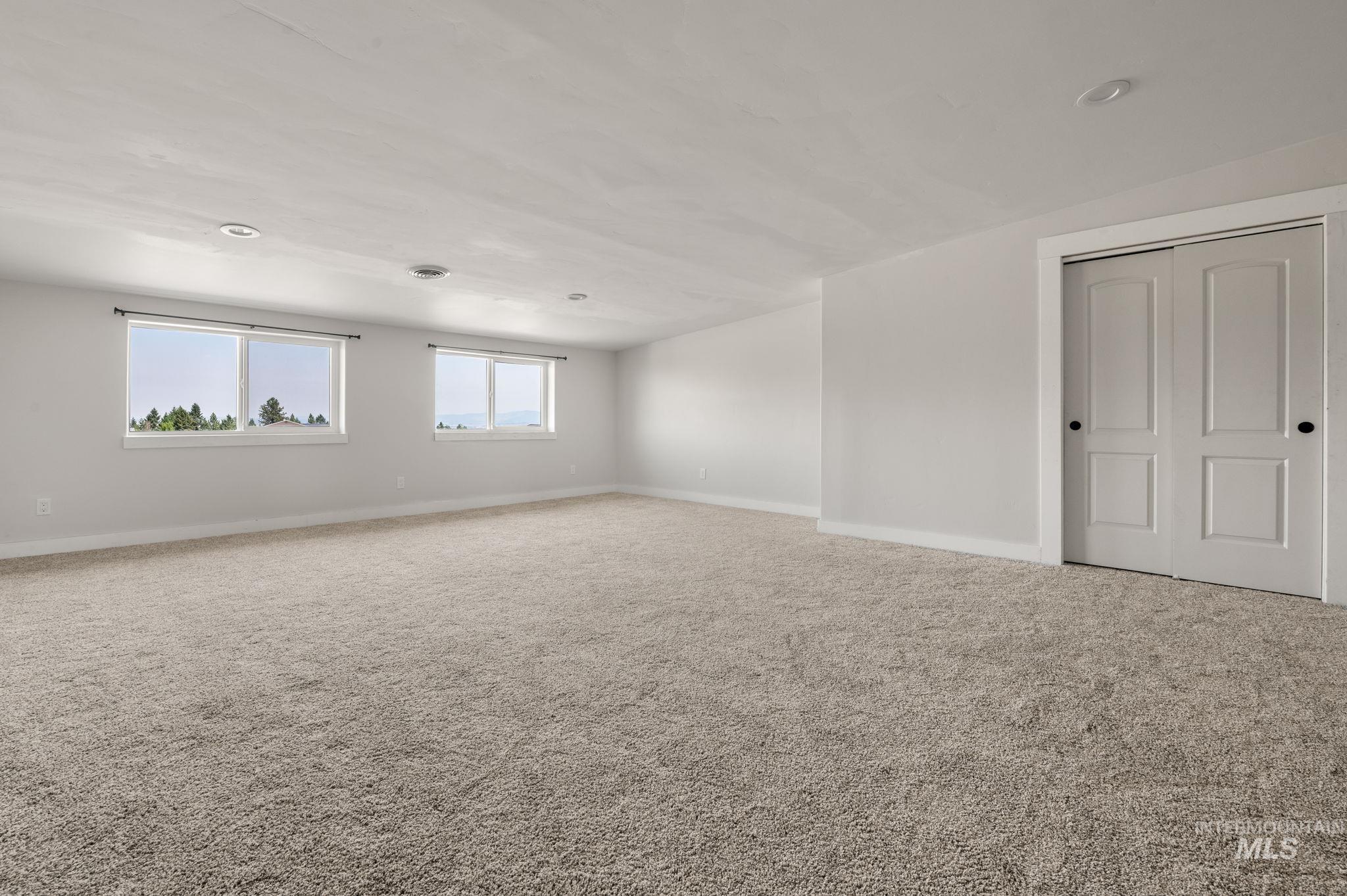 Carpeted empty room with baseboards