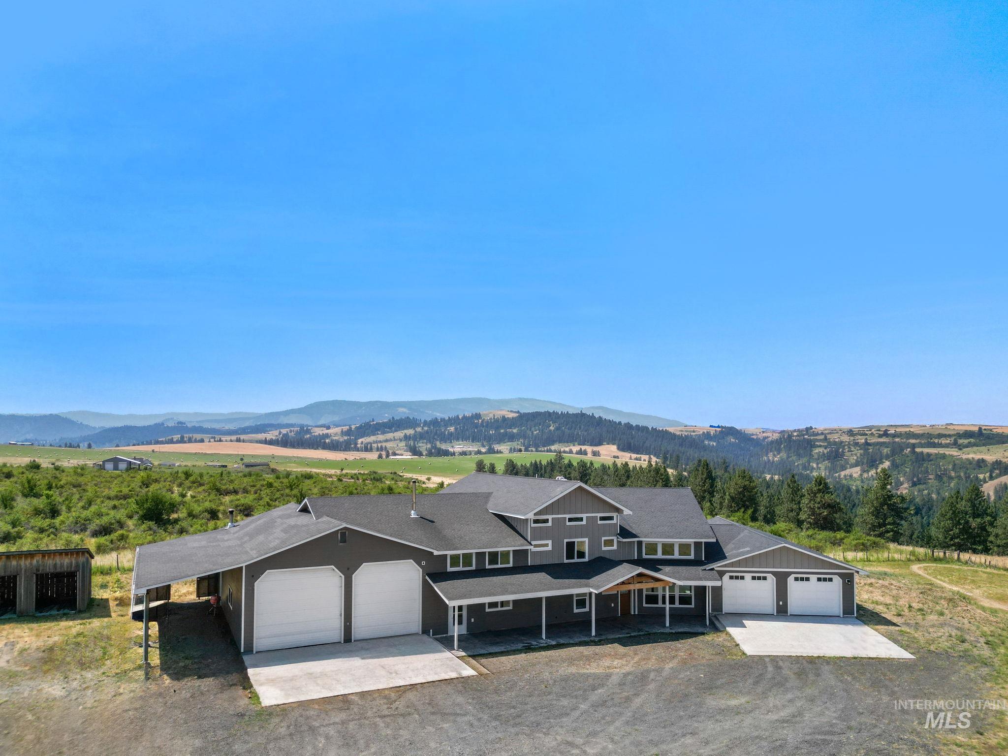 View of front facade with driveway, an attached garage, a mountain view, and a carport