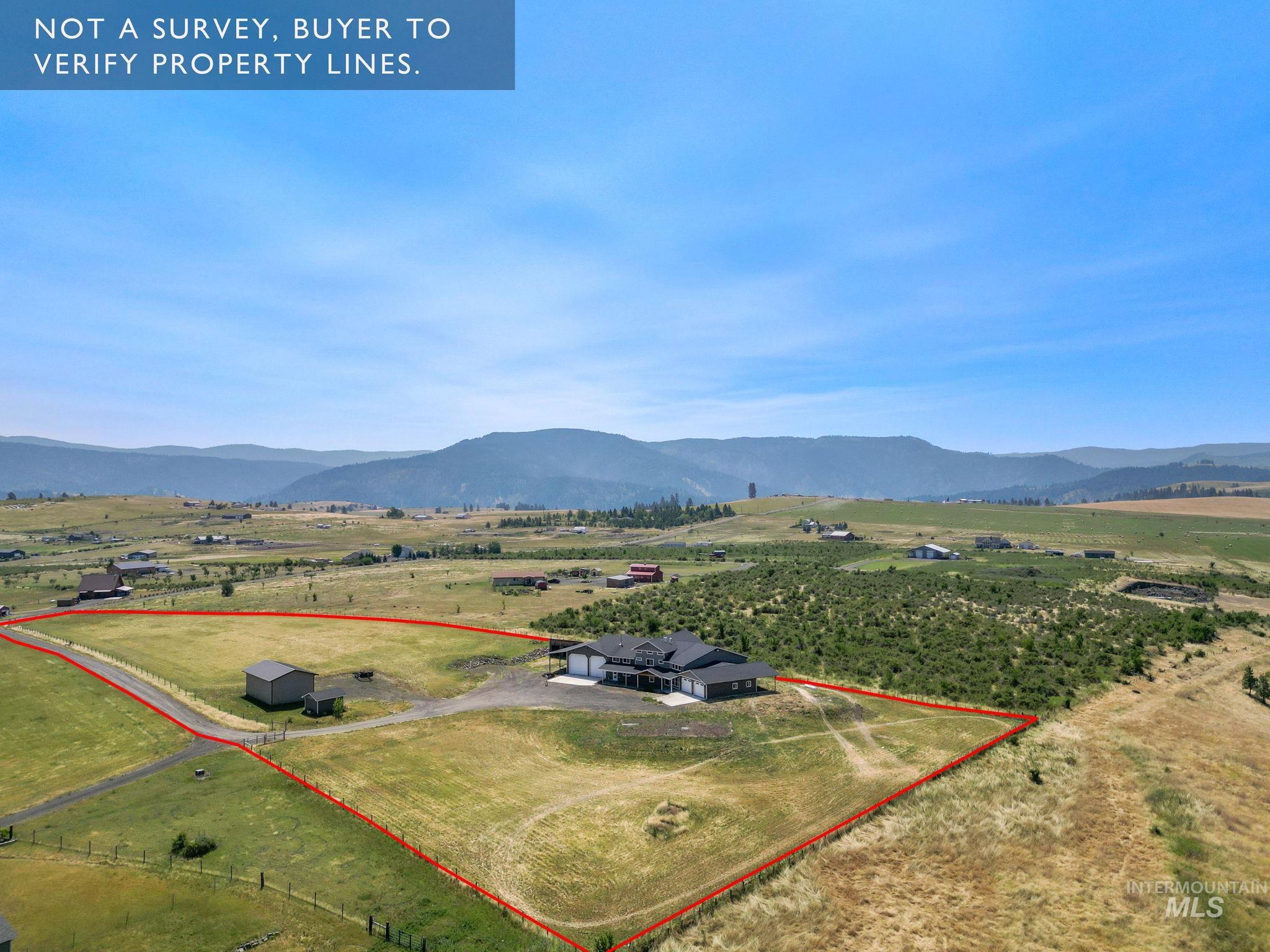 Aerial view of sparsely populated area with property boundaries highlighted and a mountain backdrop