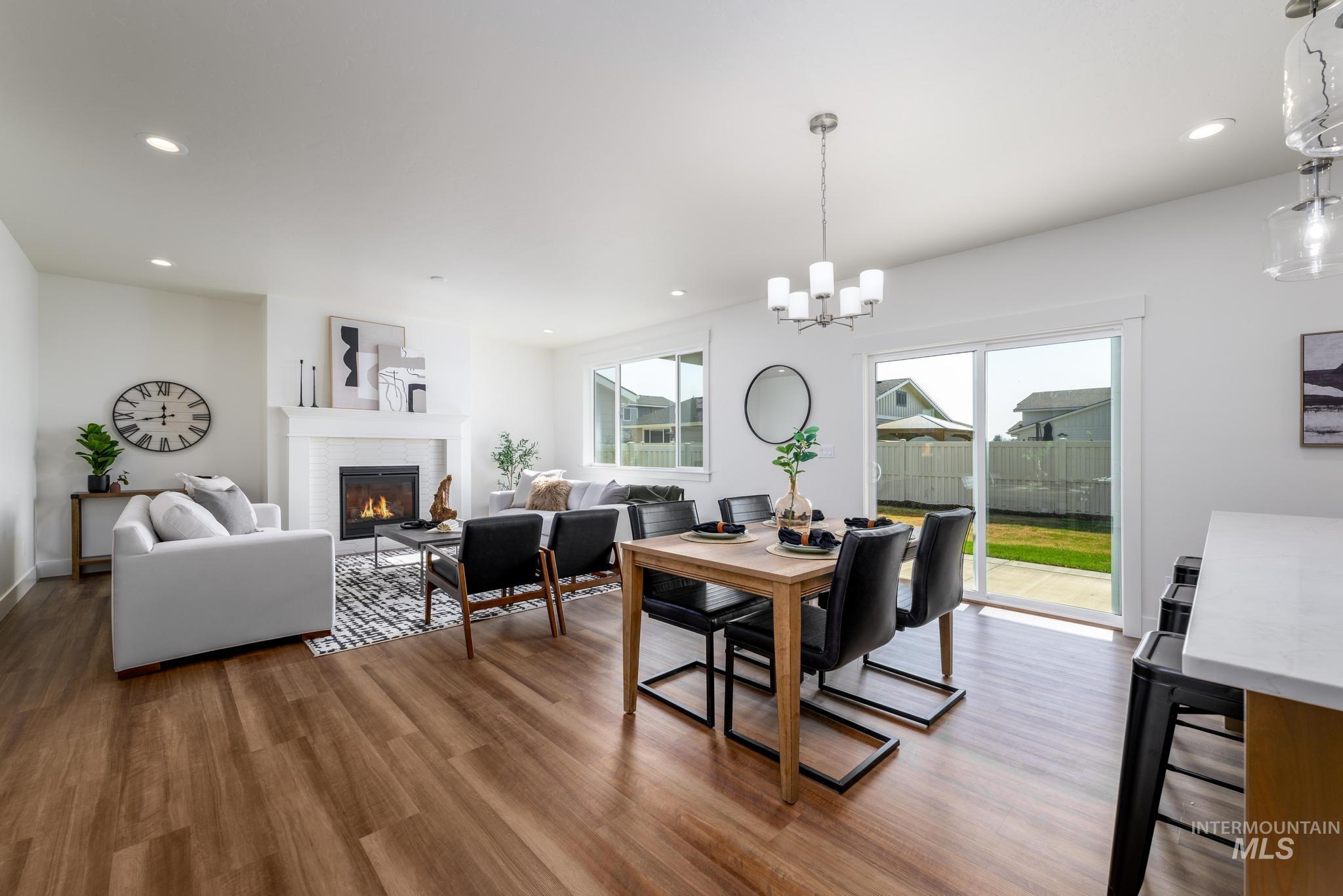 Dining room with a glass covered fireplace, light wood-type flooring, recessed lighting, and a chandelier