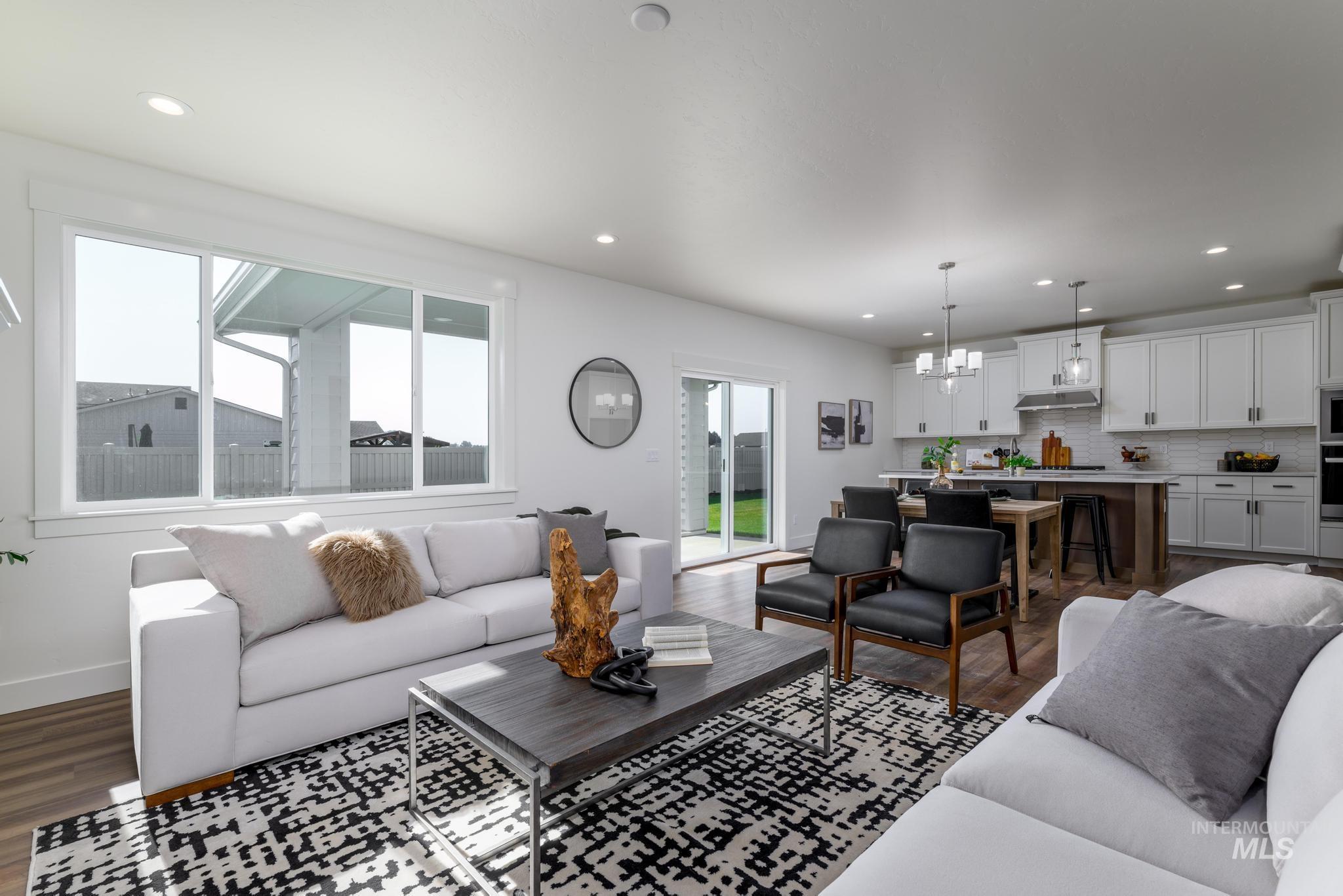 Living room featuring dark wood-style flooring, a chandelier, and recessed lighting