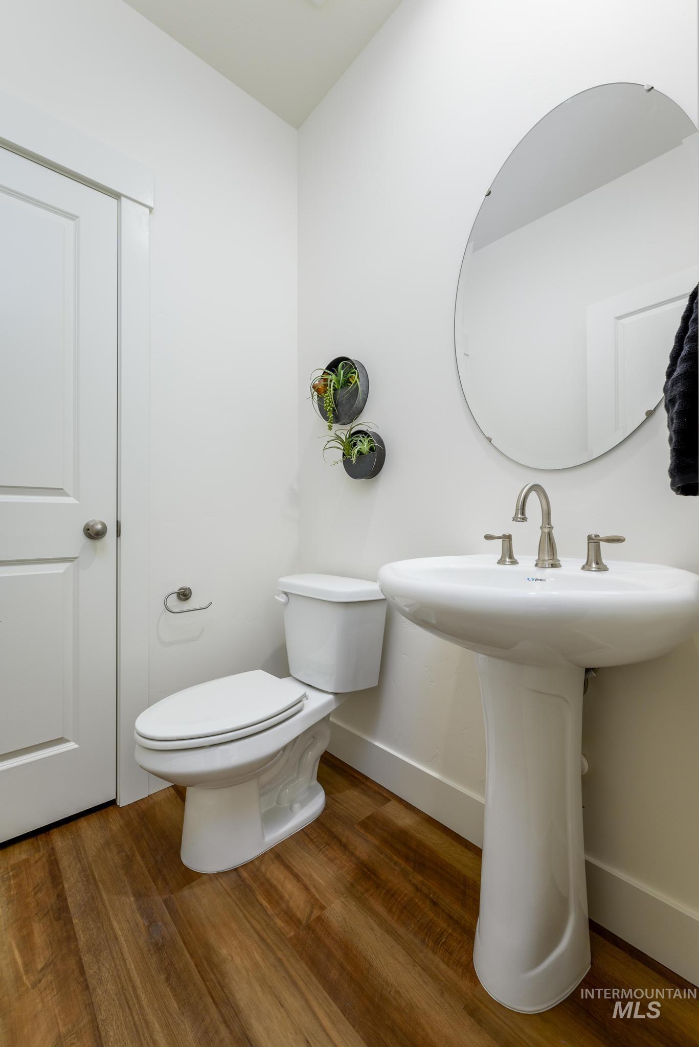 Half bath with dark wood-style flooring and baseboards