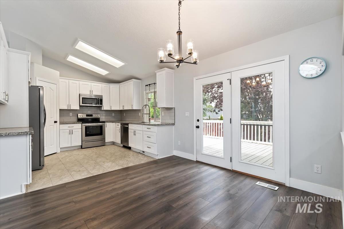 Open-concept kitchen and dining area featuring dark wood-finish flooring