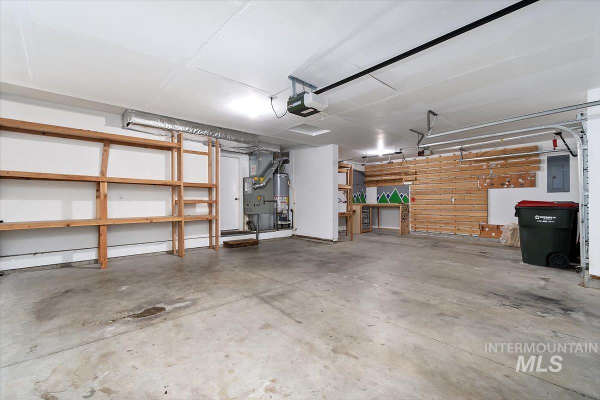 Spacious garage featuring concrete flooring and exposed ceiling ductwork