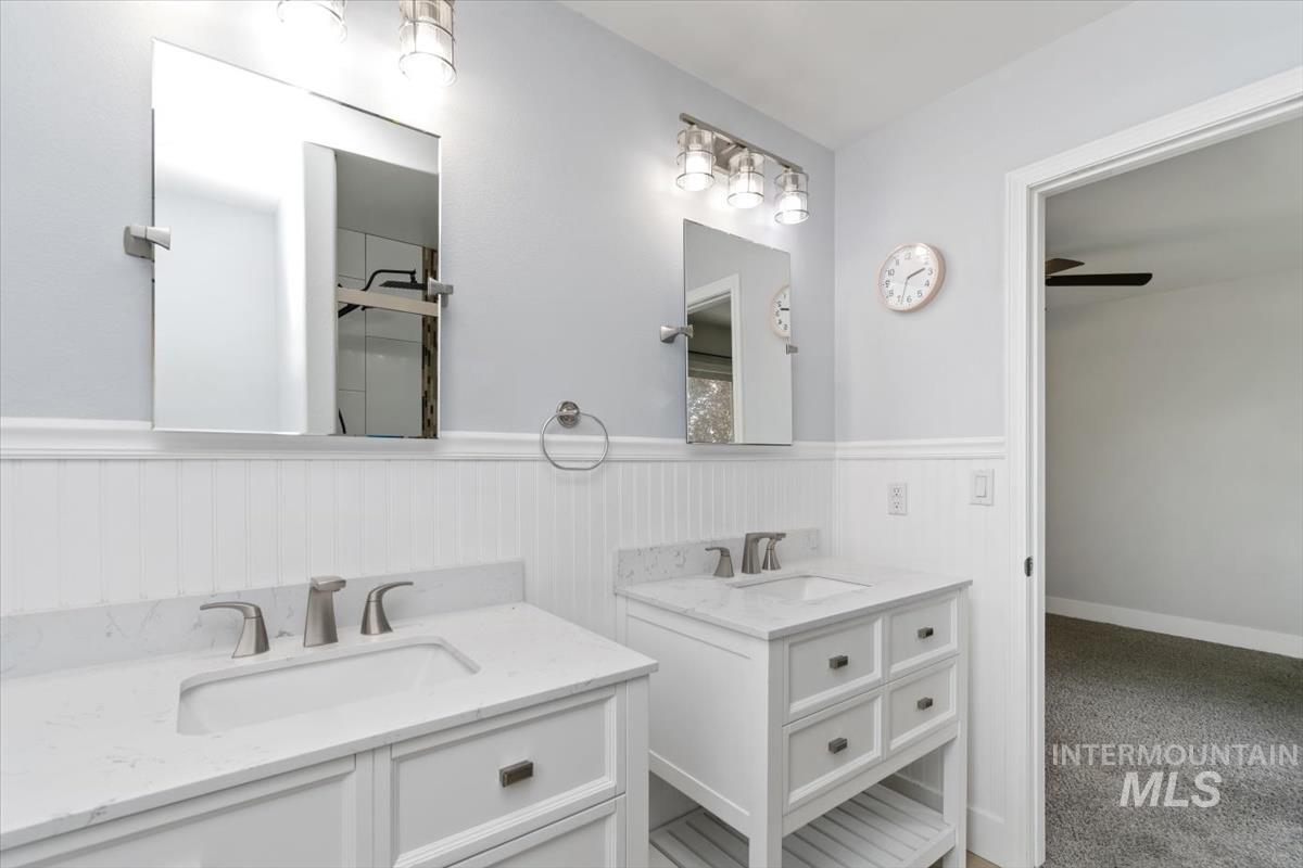 Dual vanity with white cabinetry, integrated sinks, brushed nickel fixtures, and quartz countertops