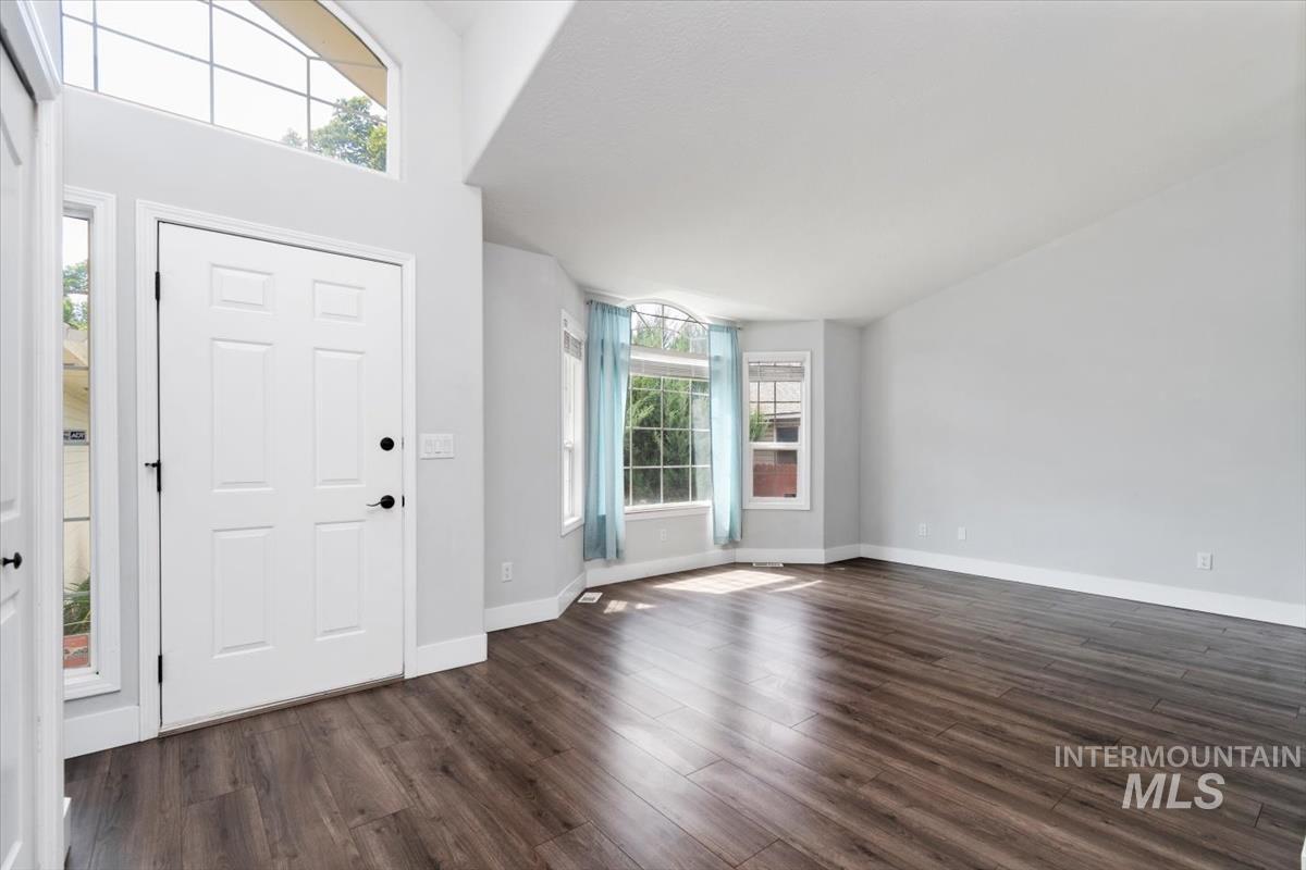 Entryway featuring a white paneled door, sidelights, and an arched transom window