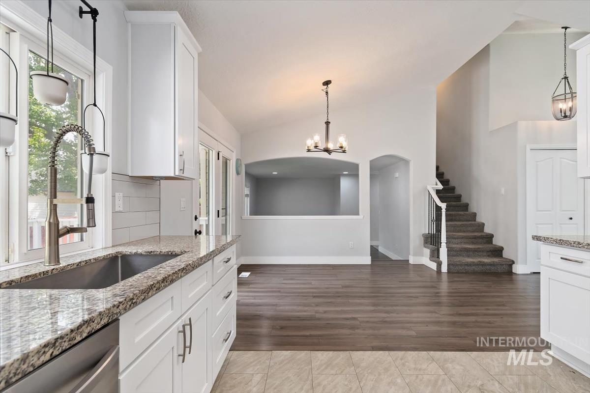 Kitchen featuring white cabinetry, granite countertops, and a subway tile backsplash