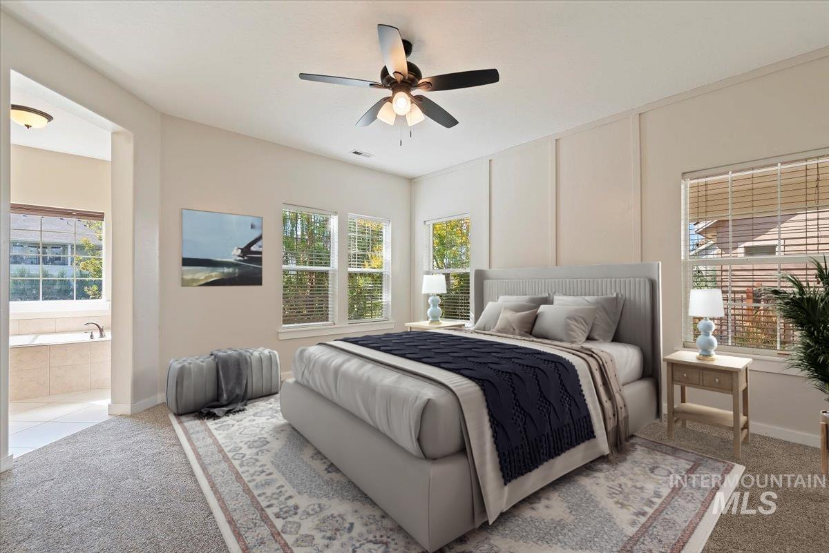 Carpeted bedroom with a ceiling fan and baseboards