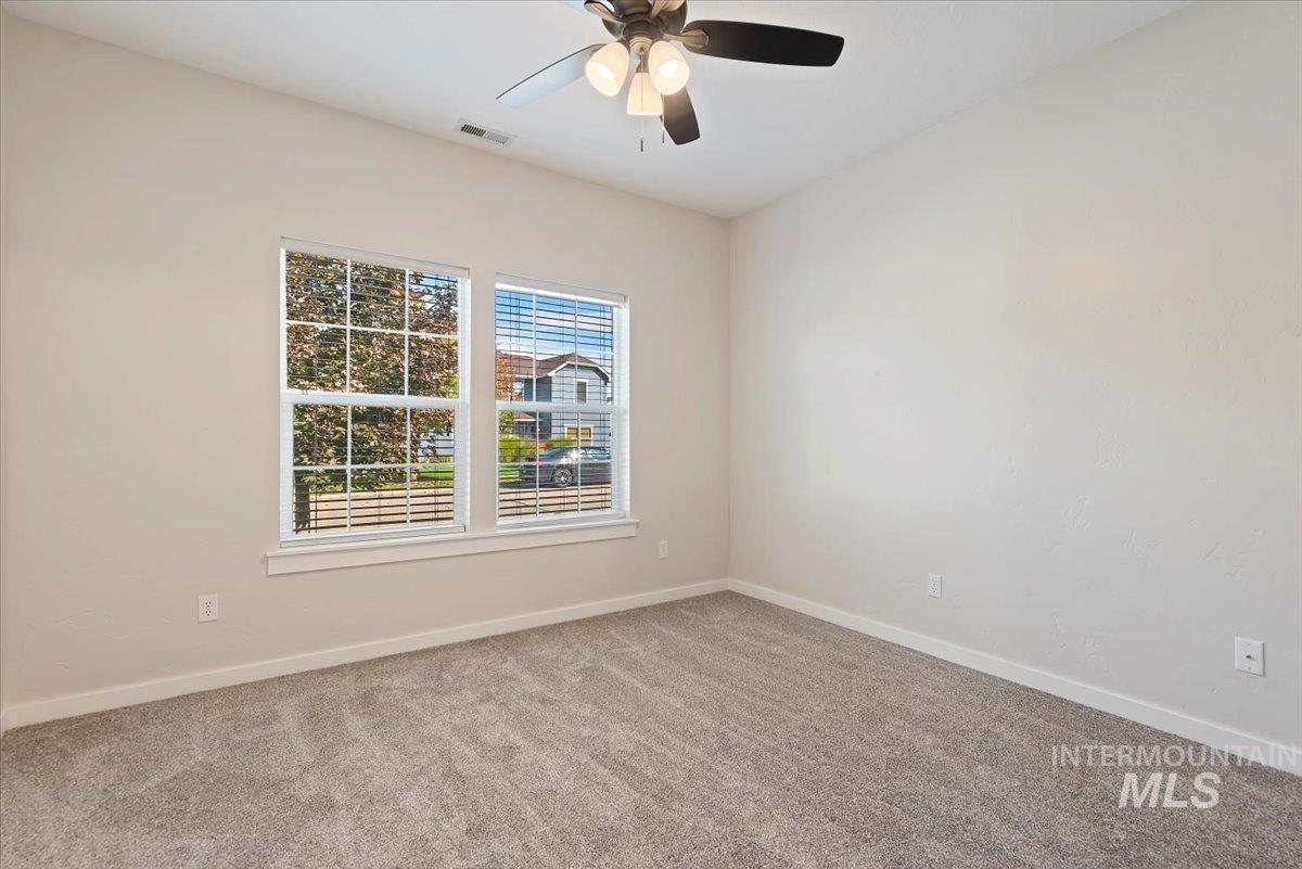 Unfurnished room featuring light carpet and ceiling fan