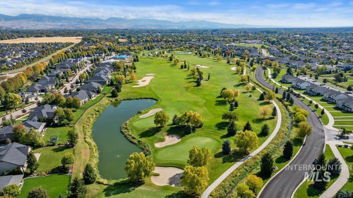 Aerial perspective of suburban area with a water and mountain view and a golf course