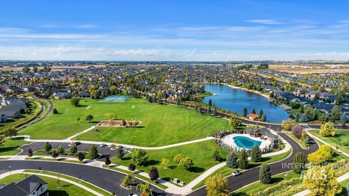 Aerial perspective of suburban area featuring a nearby body of water and a pool
