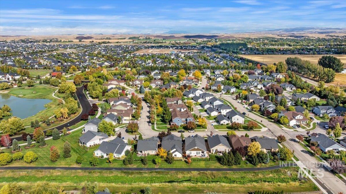 Aerial view of property and surrounding area with nearby suburban area and a large body of water