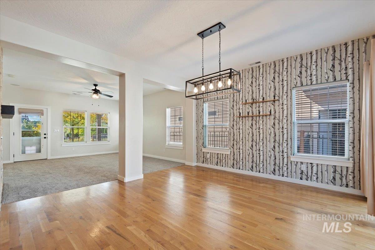 Unfurnished dining area featuring light wood-type flooring and a ceiling fan