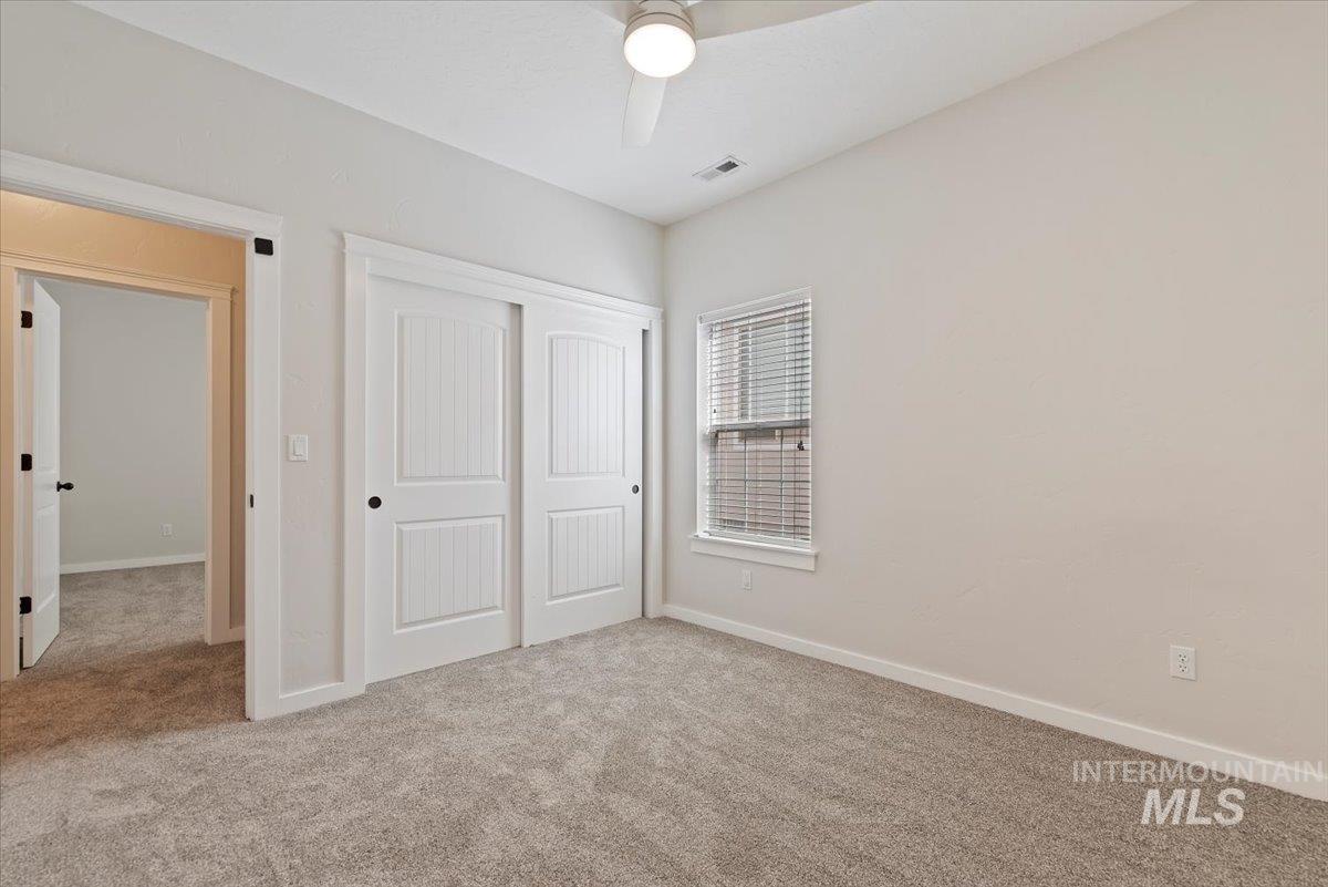 Unfurnished bedroom with carpet floors, a closet, and ceiling fan