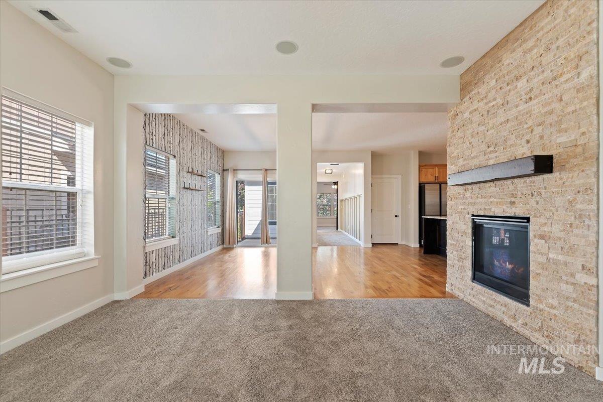 Kitchen featuring light colored carpet, a fireplace, open floor plan, light wood-style flooring, and light countertops