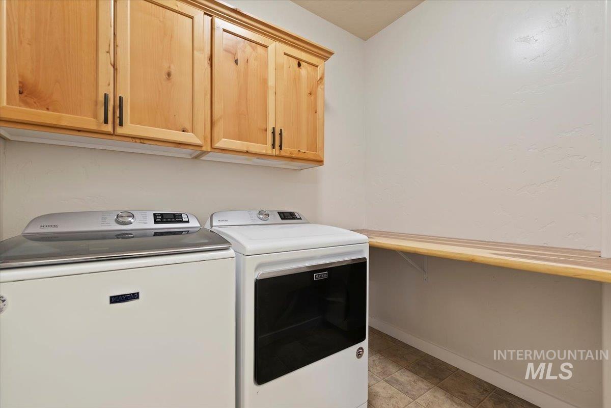 Laundry room featuring separate washer and dryer and cabinet space