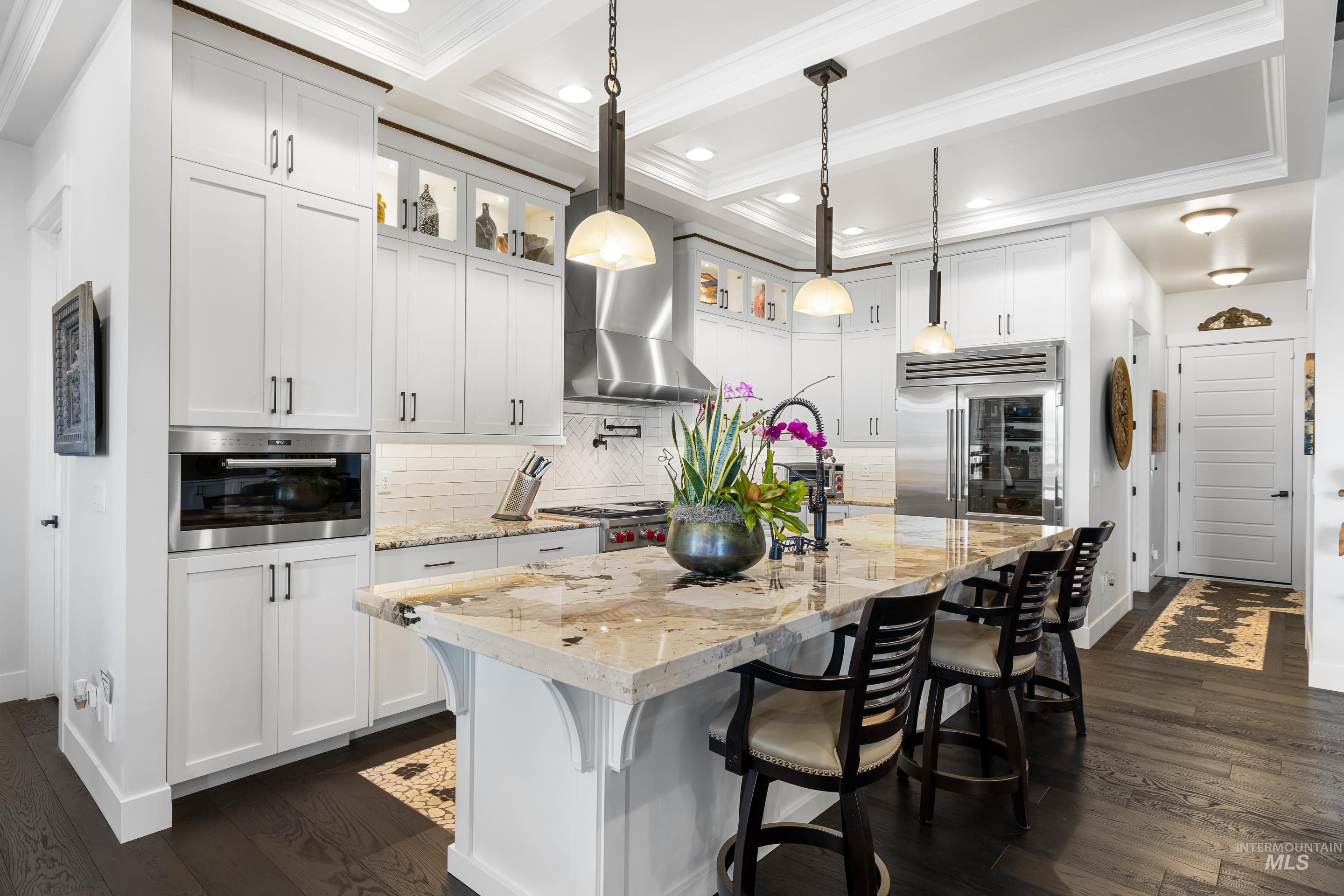 Kitchen with a kitchen breakfast bar, glass insert cabinets, decorative backsplash, dark wood-style flooring, and beam ceiling
