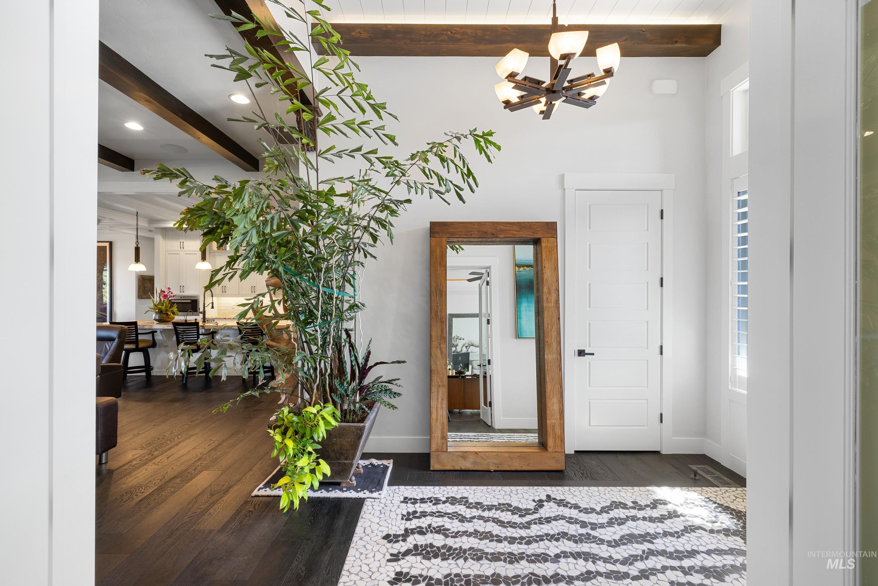 Foyer featuring beamed ceiling, dark wood finished floors, and a chandelier
