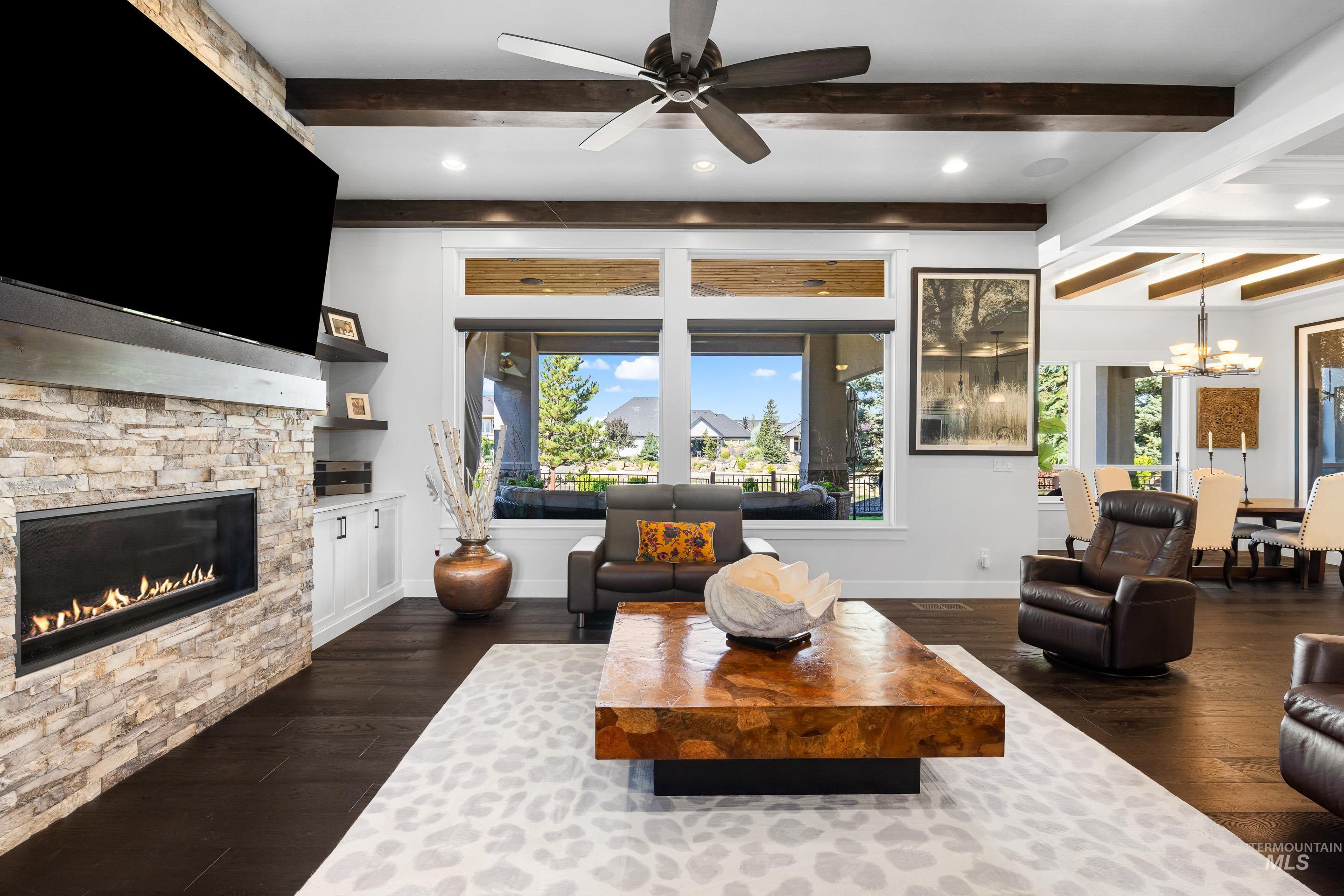 Living area with beamed ceiling, dark wood finished floors, a fireplace, ceiling fan, and recessed lighting