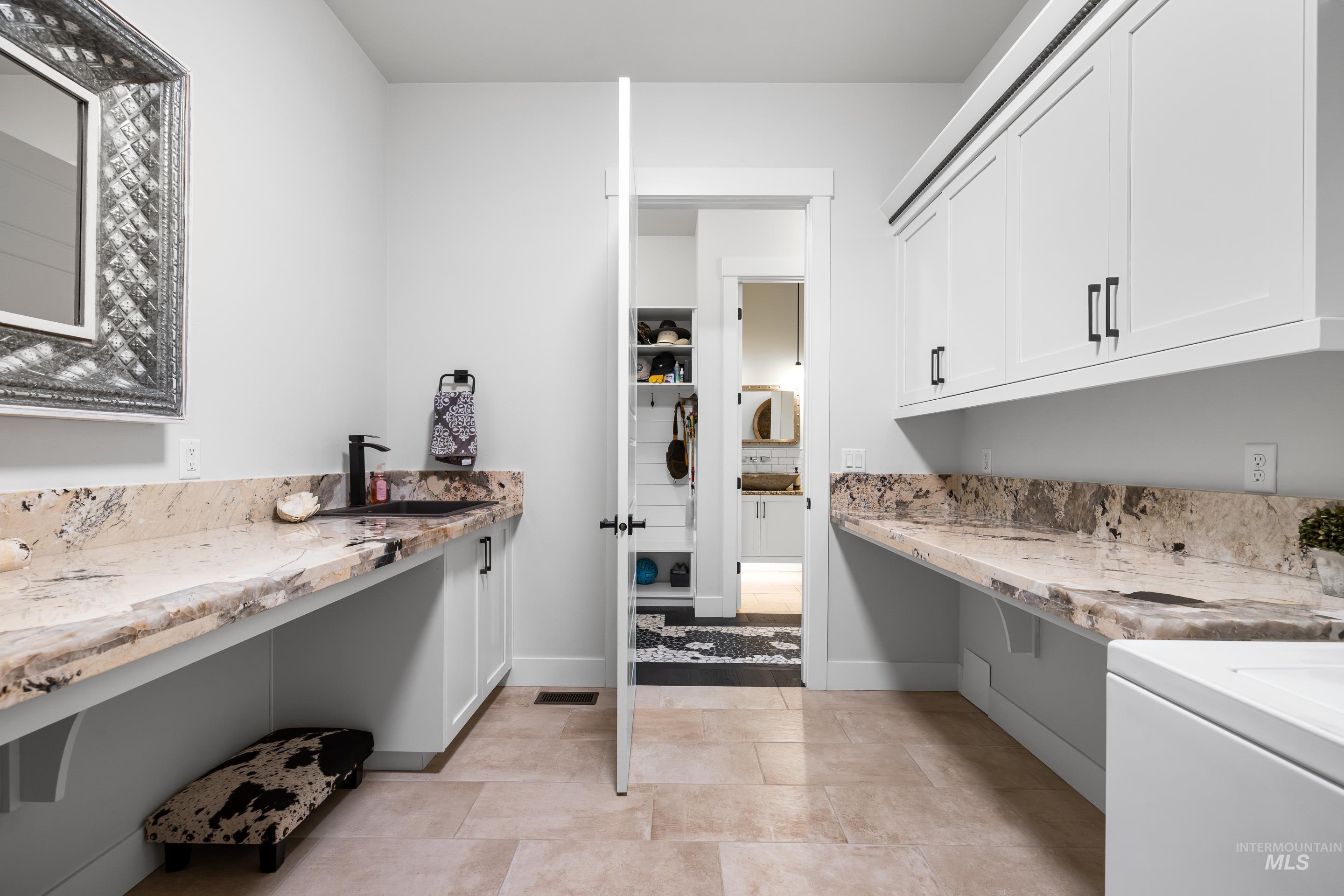 Washroom featuring cabinet space, washer / dryer, and light tile patterned floors